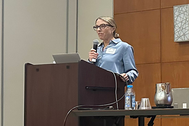 Catherine Eckel speaking at a podium on stage at an event